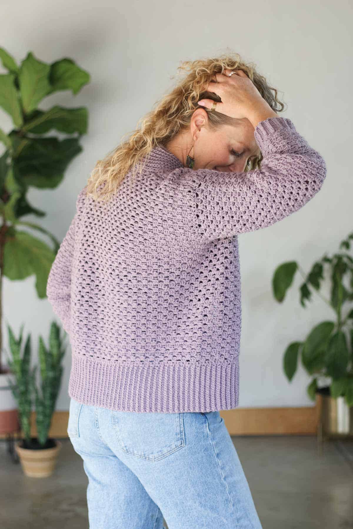 Side view of a purple, lightweight crochet cardigan with single crochet ribbing along the bottom edge.