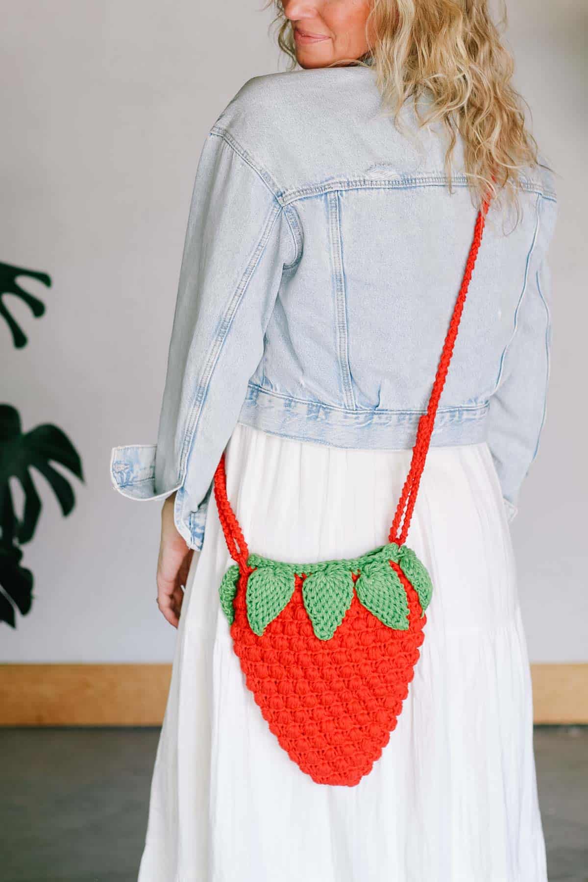 Crocheted purse in the shape of a strawberry with a Romanian cord strap.