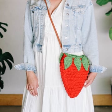 A cross-body strawberry bag crocheted with puff stitches and Tunisian crochet leaves.